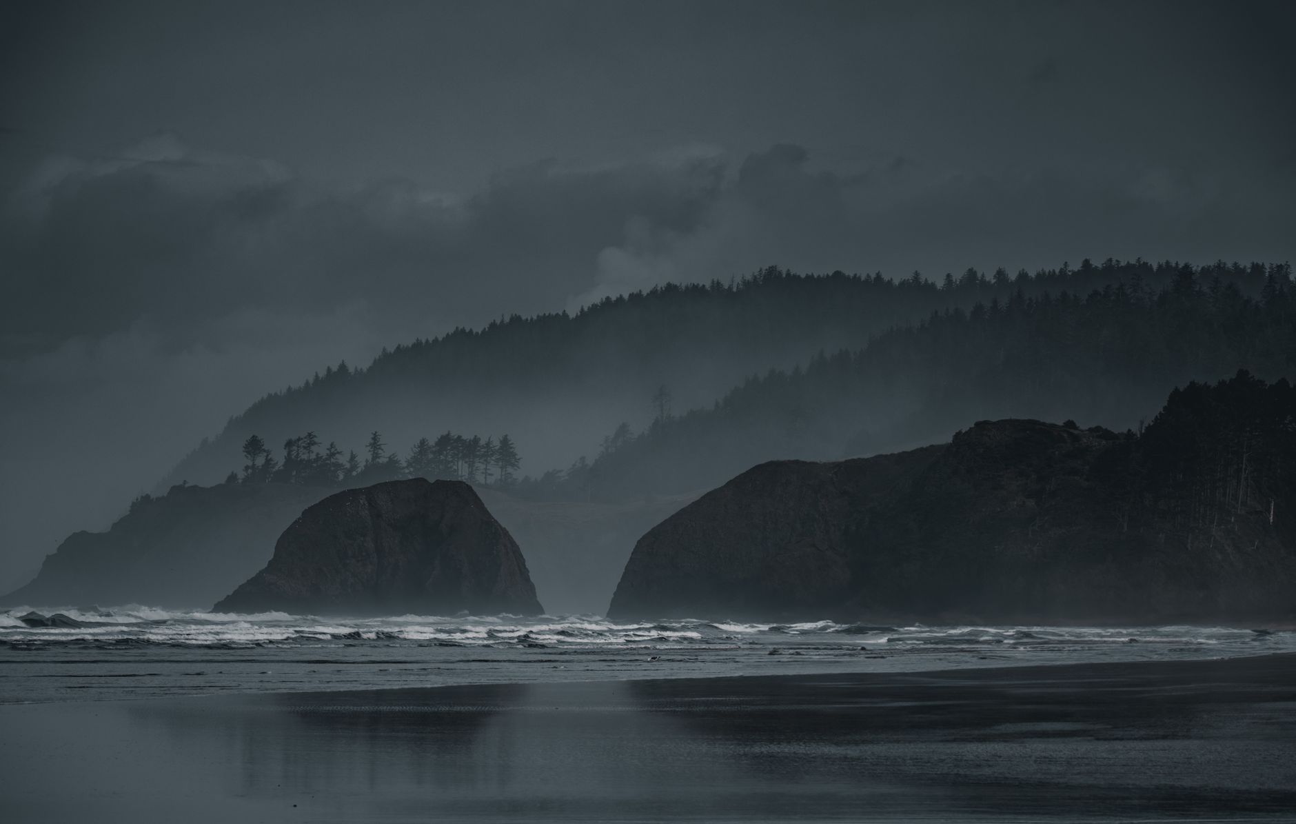 Misty beach with dramatic rock formations